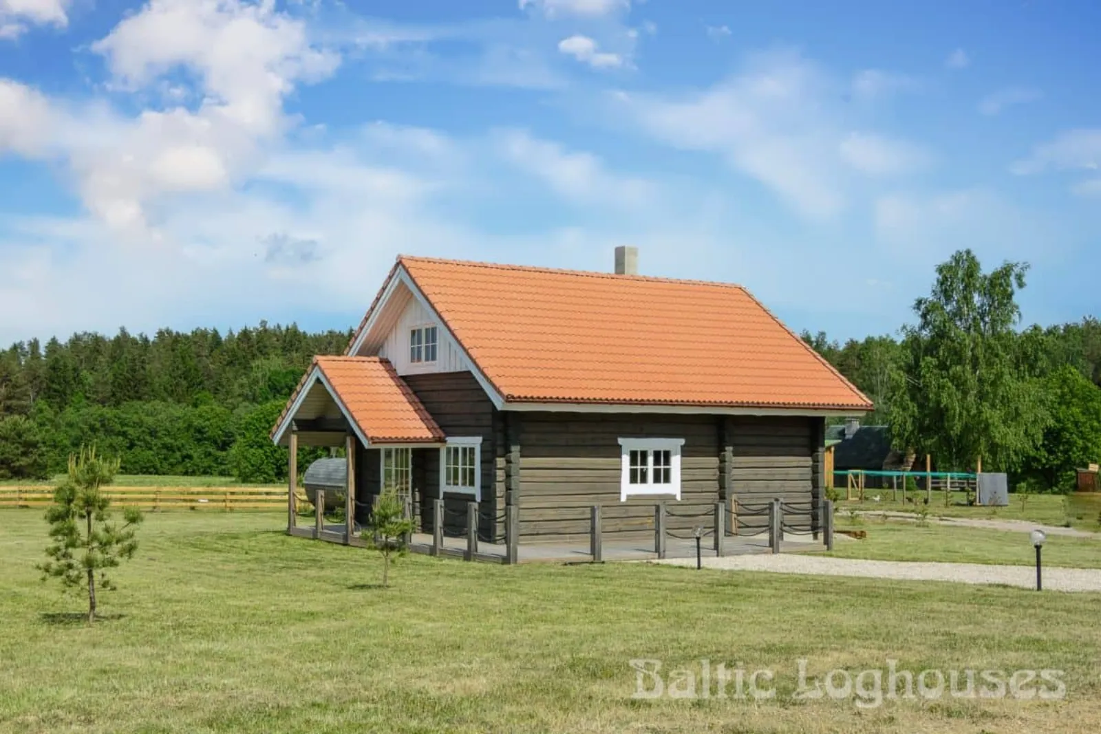 Kiidjärve palkmaja terrassi ja palkseina vaade, punane kivikatus. Töö tegi Baltic Loghouses.