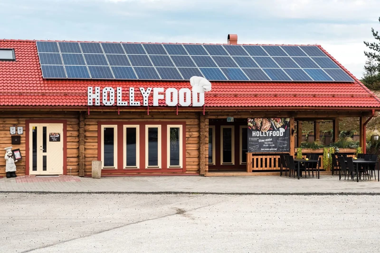 Punase katuse ja päikesepaneelidega Hollyfood toitlustushoone ümarpalgist seintega. Töö tegi L.L. House.